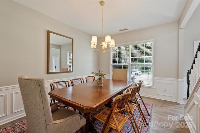 7930 Lancken Dr, Charlotte, NC 28277 - dining space with light wood-style flooring, a chandelier, wainscoting, and a decorative wall