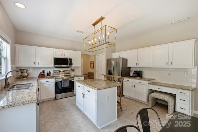 7930 Lancken Dr, Charlotte, NC 28277 - kitchen with appliances with stainless steel finishes, backsplash, white cabinetry, and light stone counters