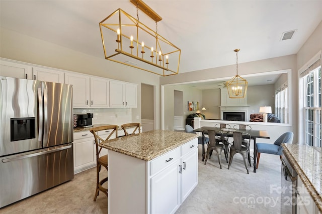 7930 Lancken Dr, Charlotte, NC 28277 - kitchen featuring stainless steel refrigerator with ice dispenser, white cabinets, and decorative light fixtures