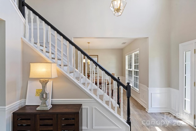 7930 Lancken Dr, Charlotte, NC 28277 - stairs with wood finished floors, a high ceiling, wainscoting, and a decorative wall