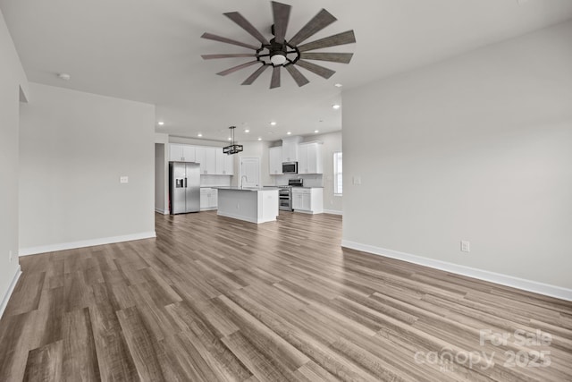 4502 Bright Rd, Charlotte, NC 28214 - unfurnished living room featuring a ceiling fan, light wood finished floors, and recessed lighting