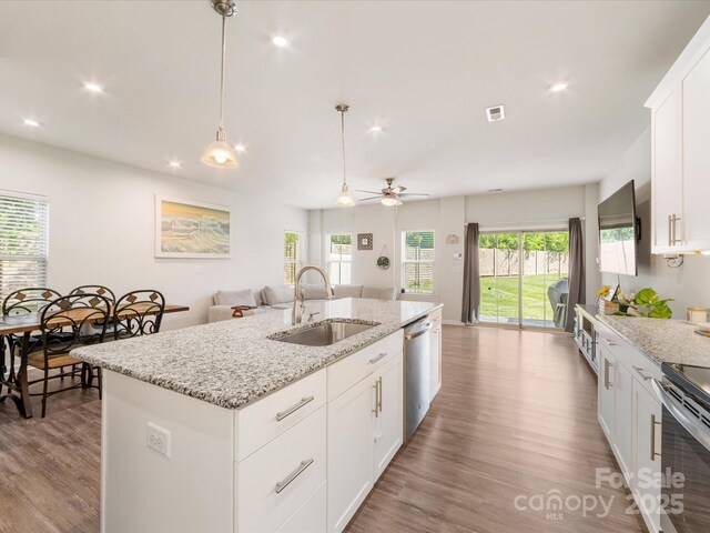 510 Park Meadows Dr, Matthews, NC 28104 - kitchen with appliances with stainless steel finishes, wood finished floors, open floor plan, an island with sink, and white cabinets