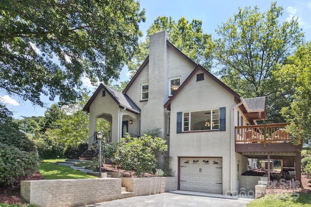 39 Nix Rd, Hendersonville, NC 28792 - tudor home with an attached garage, a chimney, driveway, a deck, and stucco siding