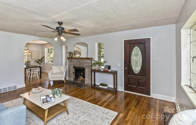 39 Nix Rd, Hendersonville, NC 28792 - living room with arched walkways, a brick fireplace, ceiling fan, a textured ceiling, and wood finished floors