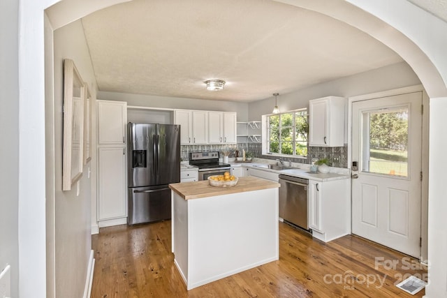 39 Nix Rd, Hendersonville, NC 28792 - kitchen featuring appliances with stainless steel finishes, butcher block counters, white cabinetry, arched walkways, and decorative backsplash