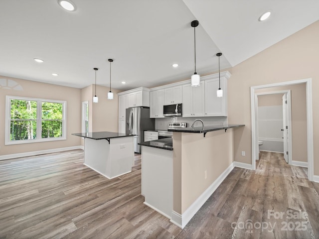 205 S Hill Ave, Albemarle, NC 28001 - kitchen with stainless steel appliances, white cabinets, dark countertops, a breakfast bar area, and recessed lighting