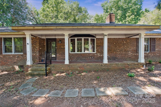 10120 Withers Rd, Charlotte, NC 28278 - property entrance with brick siding, a chimney, and covered porch