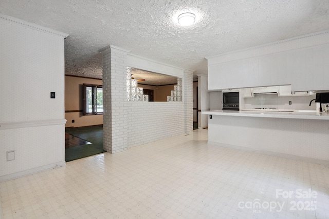 10120 Withers Rd, Charlotte, NC 28278 - kitchen featuring light floors, ornamental molding, white cabinetry, light countertops, and ornate columns