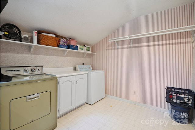 10120 Withers Rd, Charlotte, NC 28278 - laundry area featuring washer and dryer, wallpapered walls, light floors, and cabinet space