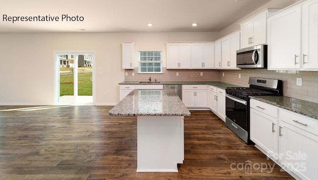 9223 Poquoson Dr, Gastonia, NC 28056 - kitchen with stainless steel appliances, recessed lighting, a kitchen island, backsplash, and white cabinetry