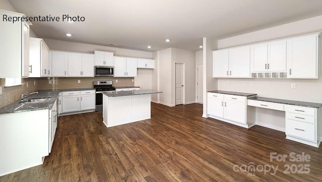 9223 Poquoson Dr, Gastonia, NC 28056 - kitchen with stainless steel appliances, tasteful backsplash, dark wood-type flooring, dark stone counters, and white cabinets