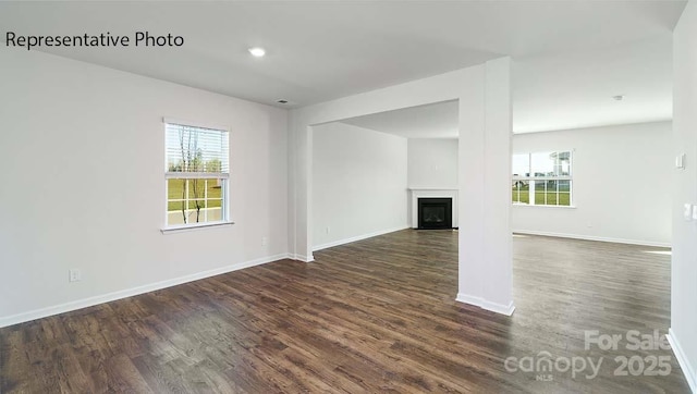 9223 Poquoson Dr, Gastonia, NC 28056 - unfurnished living room with plenty of natural light, dark wood finished floors, a glass covered fireplace, and recessed lighting