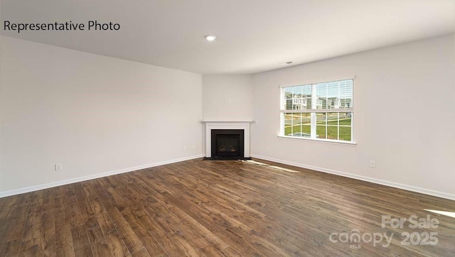 9223 Poquoson Dr, Gastonia, NC 28056 - unfurnished living room featuring a fireplace with flush hearth, dark wood-style floors, and recessed lighting