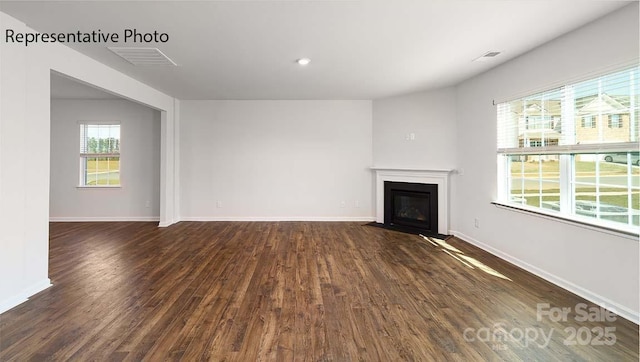 9223 Poquoson Dr, Gastonia, NC 28056 - unfurnished living room featuring dark wood-type flooring and a fireplace with flush hearth