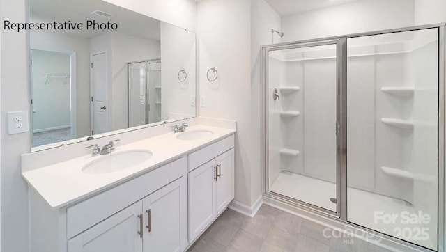 9223 Poquoson Dr, Gastonia, NC 28056 - full bath featuring a stall shower, double vanity, and a walk in closet