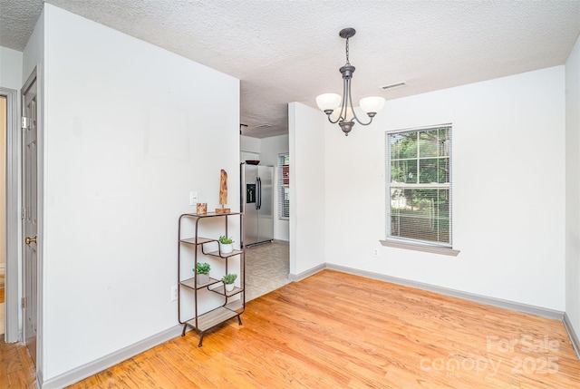 3630 Melrose Cottage Dr, Matthews, NC 28105 - unfurnished room with a chandelier, a textured ceiling, and wood finished floors