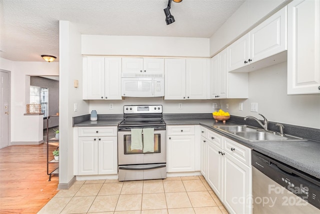 3630 Melrose Cottage Dr, Matthews, NC 28105 - kitchen featuring appliances with stainless steel finishes, a textured ceiling, white cabinetry, dark countertops, and light tile patterned floors