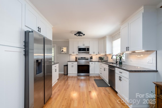304 Sowers Ferry Rd, Salisbury, NC 28144 - kitchen with appliances with stainless steel finishes, white cabinets, tasteful backsplash, and light wood finished floors