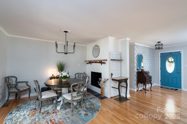 304 Sowers Ferry Rd, Salisbury, NC 28144 - dining room with ornamental molding, light wood-style flooring, a chandelier, and a brick fireplace