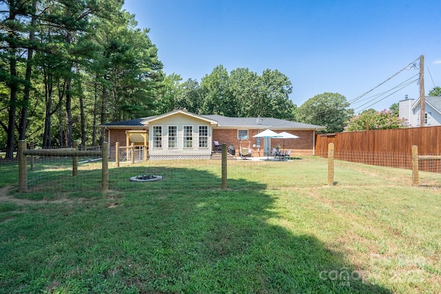 304 Sowers Ferry Rd, Salisbury, NC 28144 - back of house with brick siding, a fenced backyard, an outdoor fire pit, and a patio area