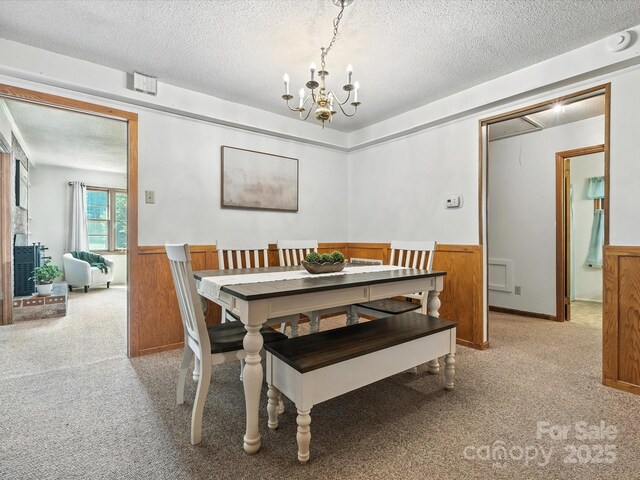 2212 Jb Denton Rd, Lancaster, SC 29720 - dining space with a chandelier, wainscoting, a textured ceiling, and light colored carpet