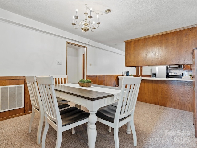 2212 Jb Denton Rd, Lancaster, SC 29720 - dining space featuring a chandelier, a textured ceiling, light carpet, and wainscoting