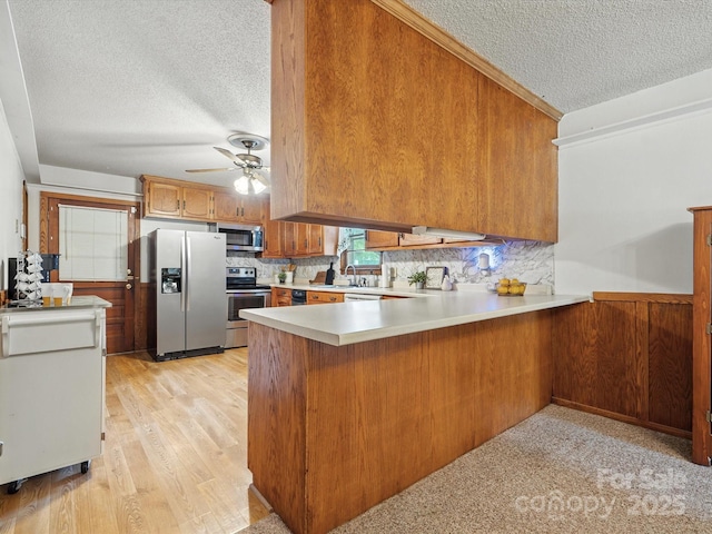 2212 Jb Denton Rd, Lancaster, SC 29720 - kitchen with stainless steel appliances, a textured ceiling, a peninsula, light countertops, and a ceiling fan