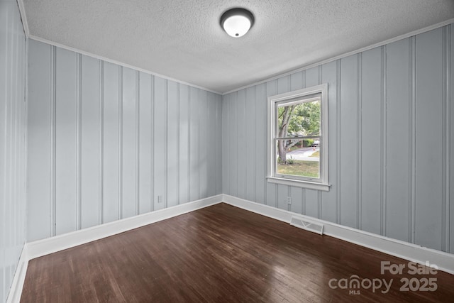 3422 Dublin Rd, Charlotte, NC 28208 - empty room with a decorative wall, a textured ceiling, dark wood-style flooring, and crown molding