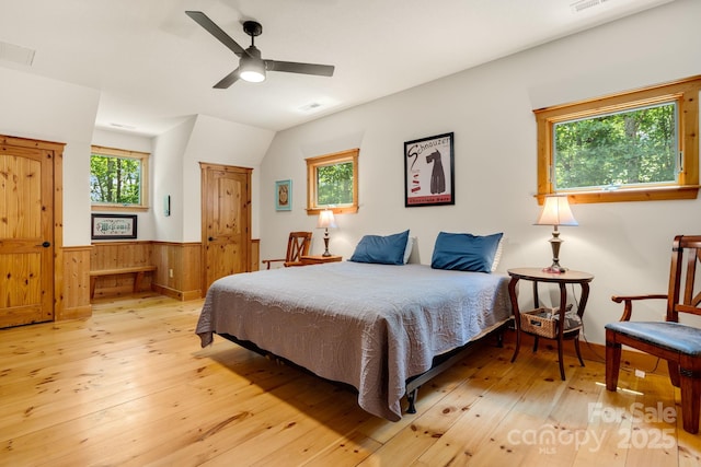 492 Henry Mountain Rd, Brevard, NC 28712 - bedroom with light wood-style floors, a wainscoted wall, multiple windows, wooden walls, and vaulted ceiling