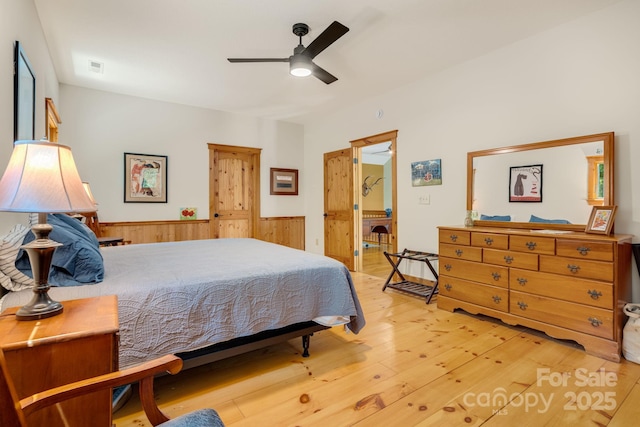 492 Henry Mountain Rd, Brevard, NC 28712 - bedroom featuring light wood finished floors, wainscoting, ceiling fan, and wooden walls