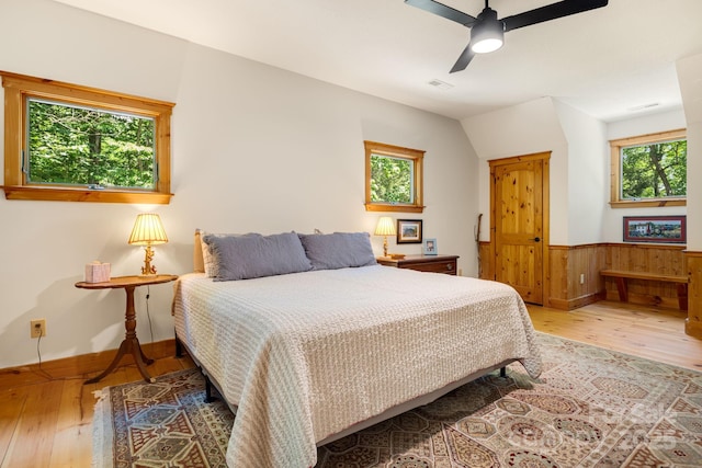 492 Henry Mountain Rd, Brevard, NC 28712 - bedroom featuring hardwood / wood-style floors, multiple windows, wainscoting, and a ceiling fan