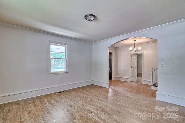 315 E Marion St, Kershaw, SC 29067 - empty room with ornamental molding, arched walkways, light wood-type flooring, and a chandelier