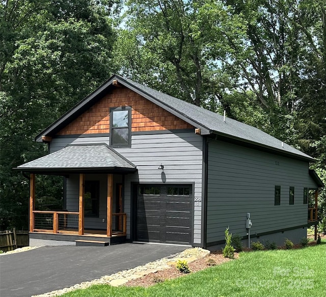 2031 S Oconeechee Ave, Black Mountain, NC 28711 - view of home's exterior with covered porch, asphalt driveway, roof with shingles, and a lawn