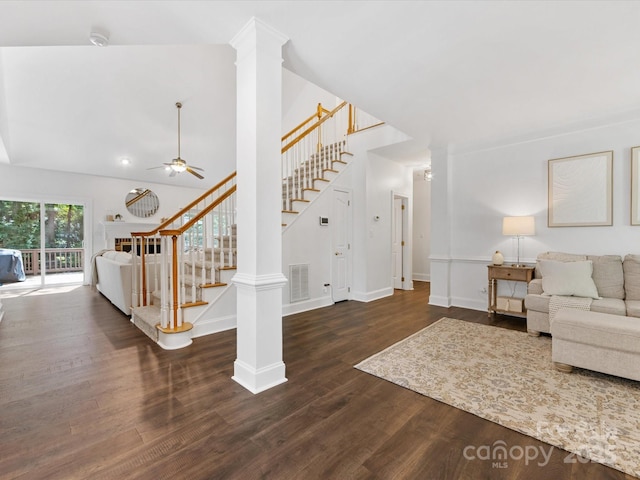 10527 Breamore Dr, Charlotte, NC 28270 - living room featuring stairs, dark wood-style floors, ceiling fan, ornate columns, and high vaulted ceiling