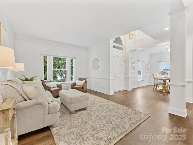 10527 Breamore Dr, Charlotte, NC 28270 - living area featuring healthy amount of natural light, a chandelier, ornate columns, dark wood finished floors, and crown molding