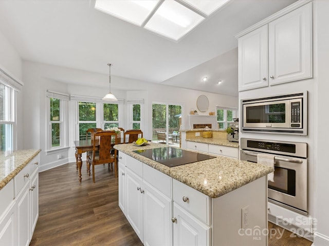 10527 Breamore Dr, Charlotte, NC 28270 - kitchen with appliances with stainless steel finishes, dark wood-type flooring, a center island, white cabinetry, and light stone countertops