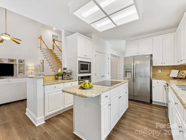 10527 Breamore Dr, Charlotte, NC 28270 - kitchen featuring appliances with stainless steel finishes, a center island, open floor plan, white cabinetry, and dark wood-type flooring