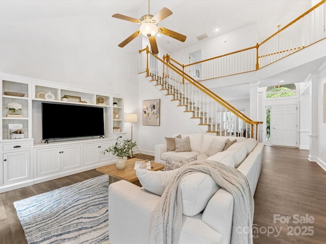 10527 Breamore Dr, Charlotte, NC 28270 - living room featuring a towering ceiling, stairway, dark wood-style floors, ornate columns, and a ceiling fan