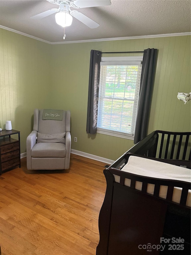 804 Lee St, Kings Mountain, NC 28086 - bedroom featuring ornamental molding, wood finished floors, a ceiling fan, a textured ceiling, and wood walls
