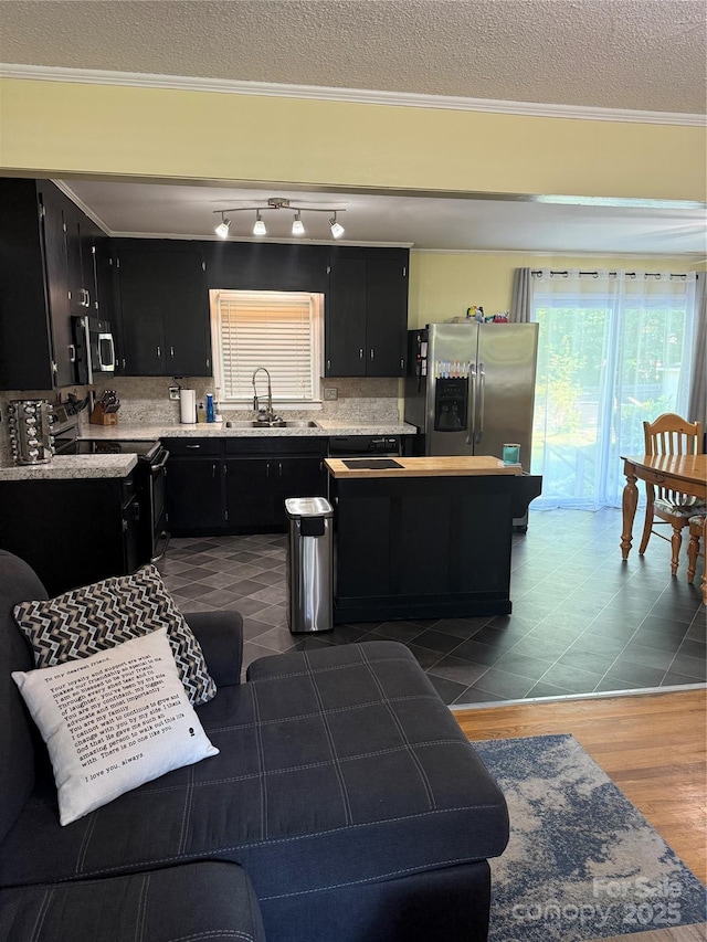 804 Lee St, Kings Mountain, NC 28086 - kitchen featuring dark cabinetry, appliances with stainless steel finishes, light countertops, a textured ceiling, and crown molding