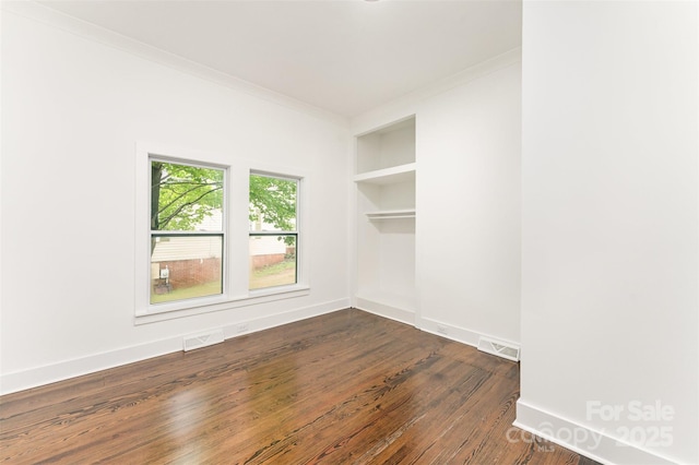 617 N Juniper Ave, Kannapolis, NC 28081 - empty room featuring dark wood-type flooring, ornamental molding, and built in features