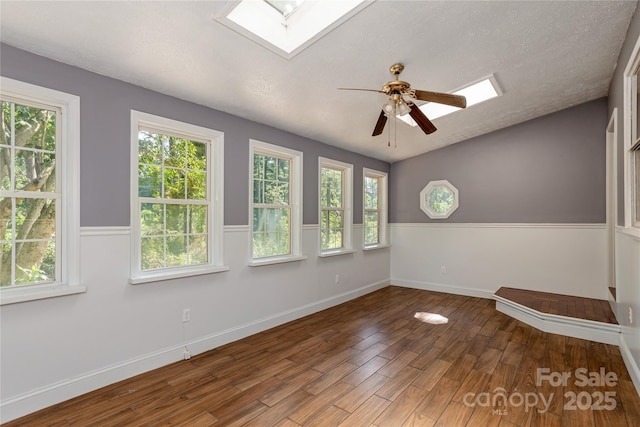 18 Peaceful Valley Ln, Flat Rock, NC 28731 - spare room featuring a skylight, wood finished floors, a ceiling fan, healthy amount of natural light, and a textured ceiling