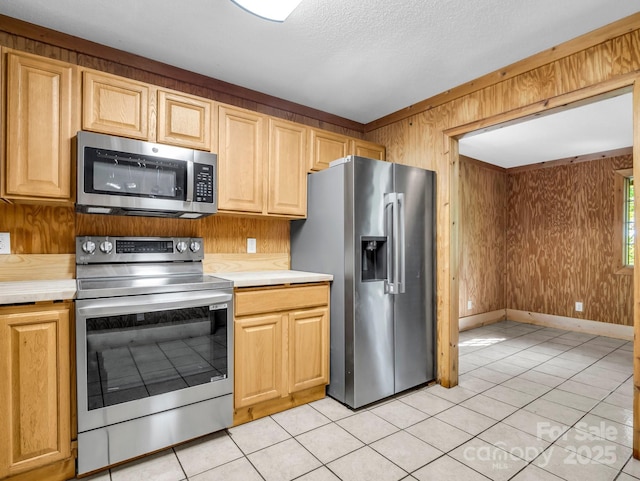 291 Pine Ridge Rd, Hendersonville, NC 28792 - kitchen with stainless steel appliances, wood walls, light countertops, light tile patterned flooring, and light brown cabinets