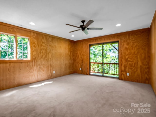 291 Pine Ridge Rd, Hendersonville, NC 28792 - carpeted empty room featuring plenty of natural light, recessed lighting, a ceiling fan, and wood walls