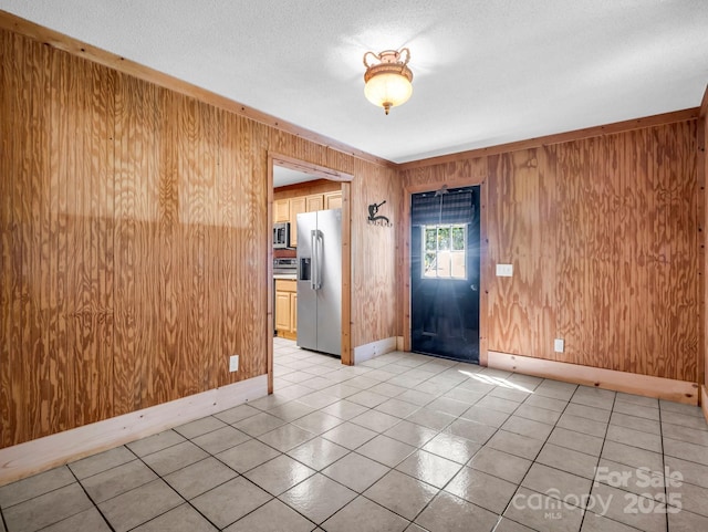 291 Pine Ridge Rd, Hendersonville, NC 28792 - entrance foyer with wood walls, light tile patterned floors, and a textured ceiling