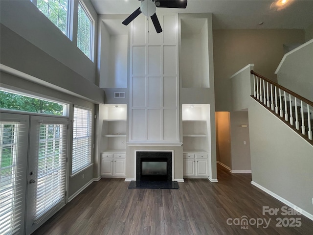 2834 Ritz Ln, Matthews, NC 28105 - unfurnished living room with a high ceiling, a fireplace, stairway, dark wood finished floors, and a ceiling fan