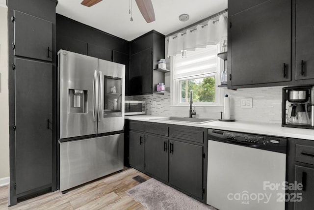 305 E Marion St, Kershaw, SC 29067 - kitchen with appliances with stainless steel finishes, open shelves, light wood-type flooring, a ceiling fan, and decorative backsplash