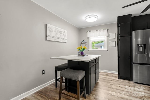 305 E Marion St, Kershaw, SC 29067 - kitchen featuring stainless steel fridge, dark cabinetry, a kitchen bar, a kitchen island, and ceiling fan