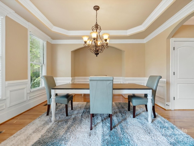 8407 Rolling Fields Rd, Mint Hill, NC 28227 - dining space featuring a chandelier, arched walkways, wood finished floors, ornamental molding, and wainscoting