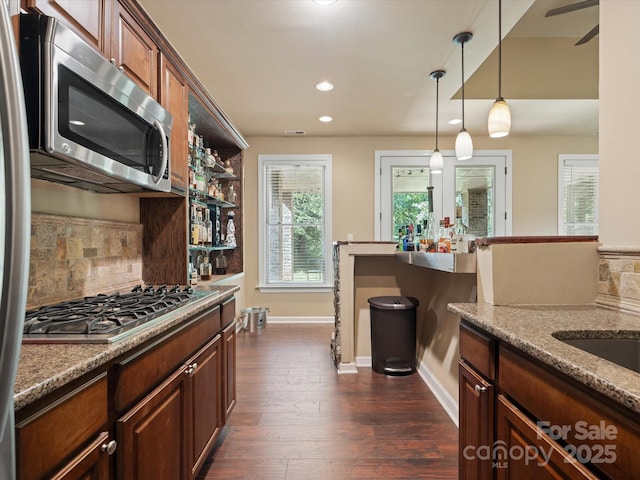 8407 Rolling Fields Rd, Mint Hill, NC 28227 - kitchen featuring appliances with stainless steel finishes, decorative backsplash, decorative light fixtures, dark wood finished floors, and light stone counters